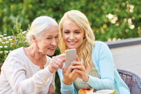 Enkelin und Grossmutter schauen auf Smartphone