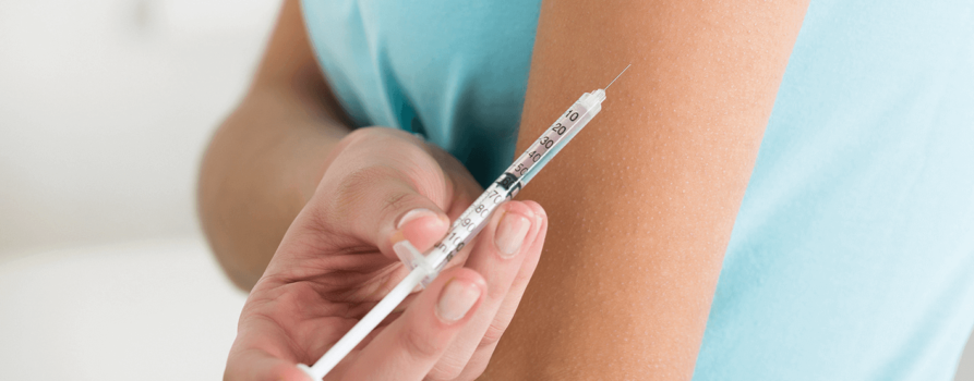 Impfung BCG, junge Frau wird in Oberarm geimpft
