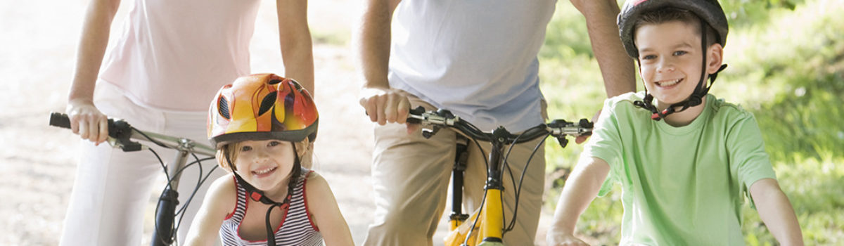 Eltern fahren Farhrrad mit zwei Kindern