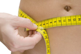 Messband um Bauch einer Frau. Übergewicht Diabetes